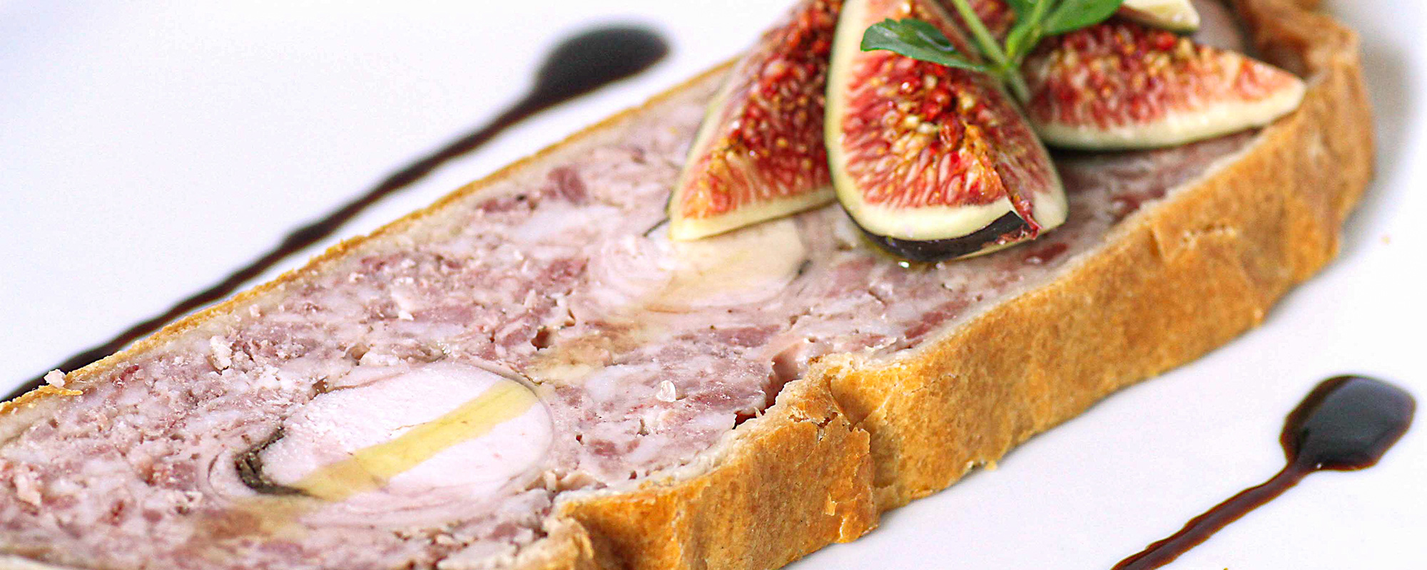 une magnifique tranche de pate en croute une magnifique tranche de pate en croute avec des figues fraiches coupées en quartier, et une, sublimé par deux traits de vignaire balsamique et herbe fraiche du jardin